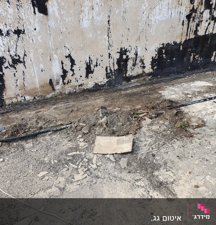 קיר עם סימני איטום ושברים על הקרקע